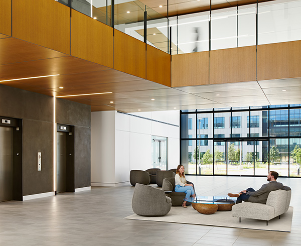 Two Karlin real estate experts sitting in an expansive lobby by elevators