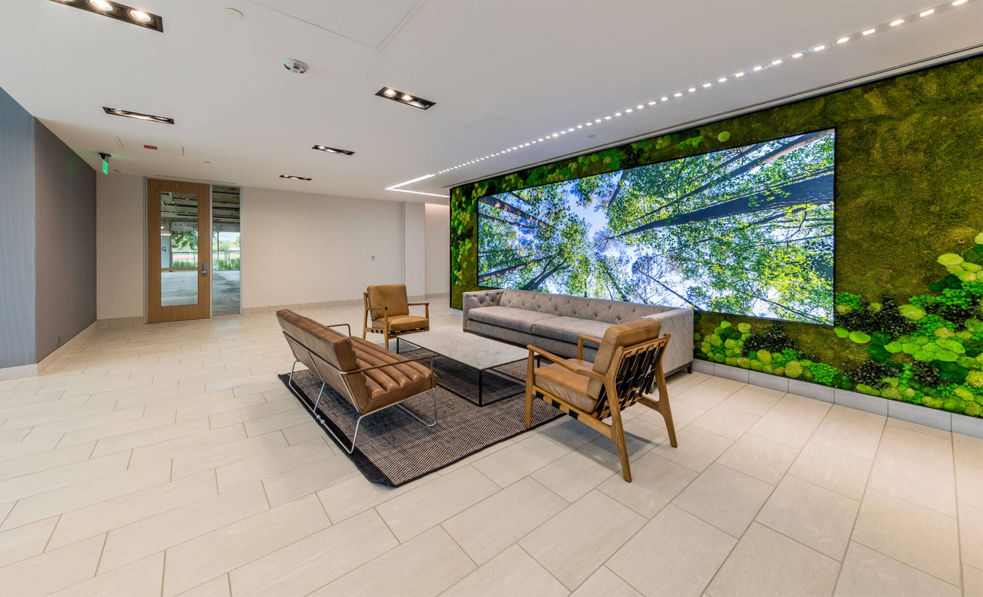 Office building lobby featuring modern furniture and a large nature-themed mural