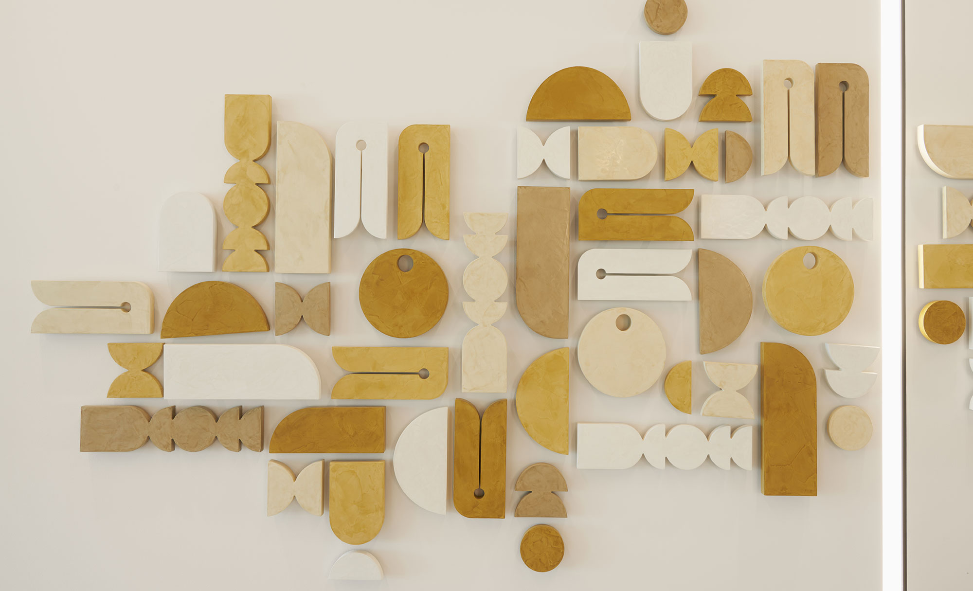 Artistic wooden wall installation with geometric shapes in Parmer 2 lobby