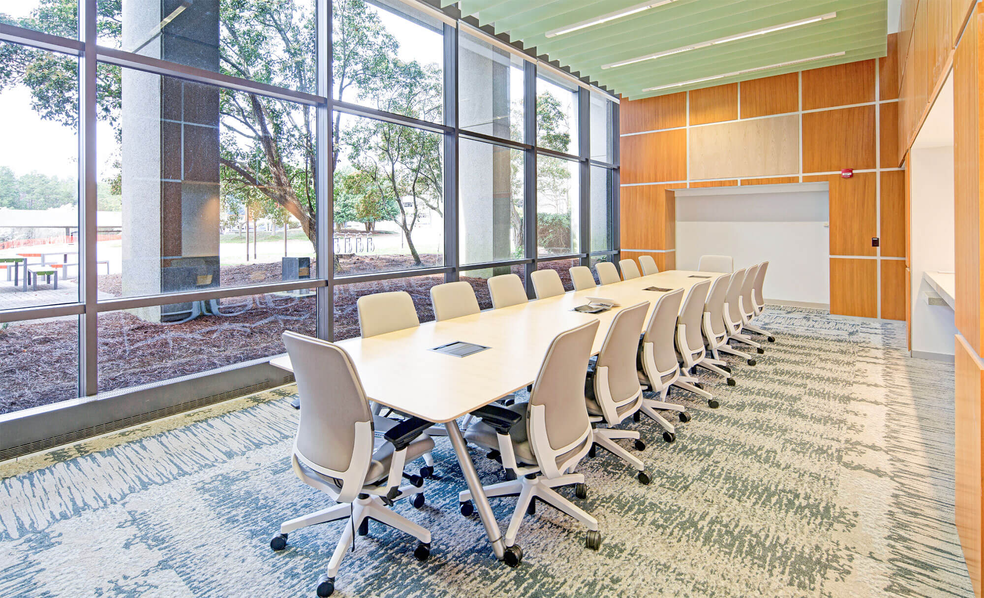 Interior of a bright conference room at Parmer RTP with large windows and white chairs