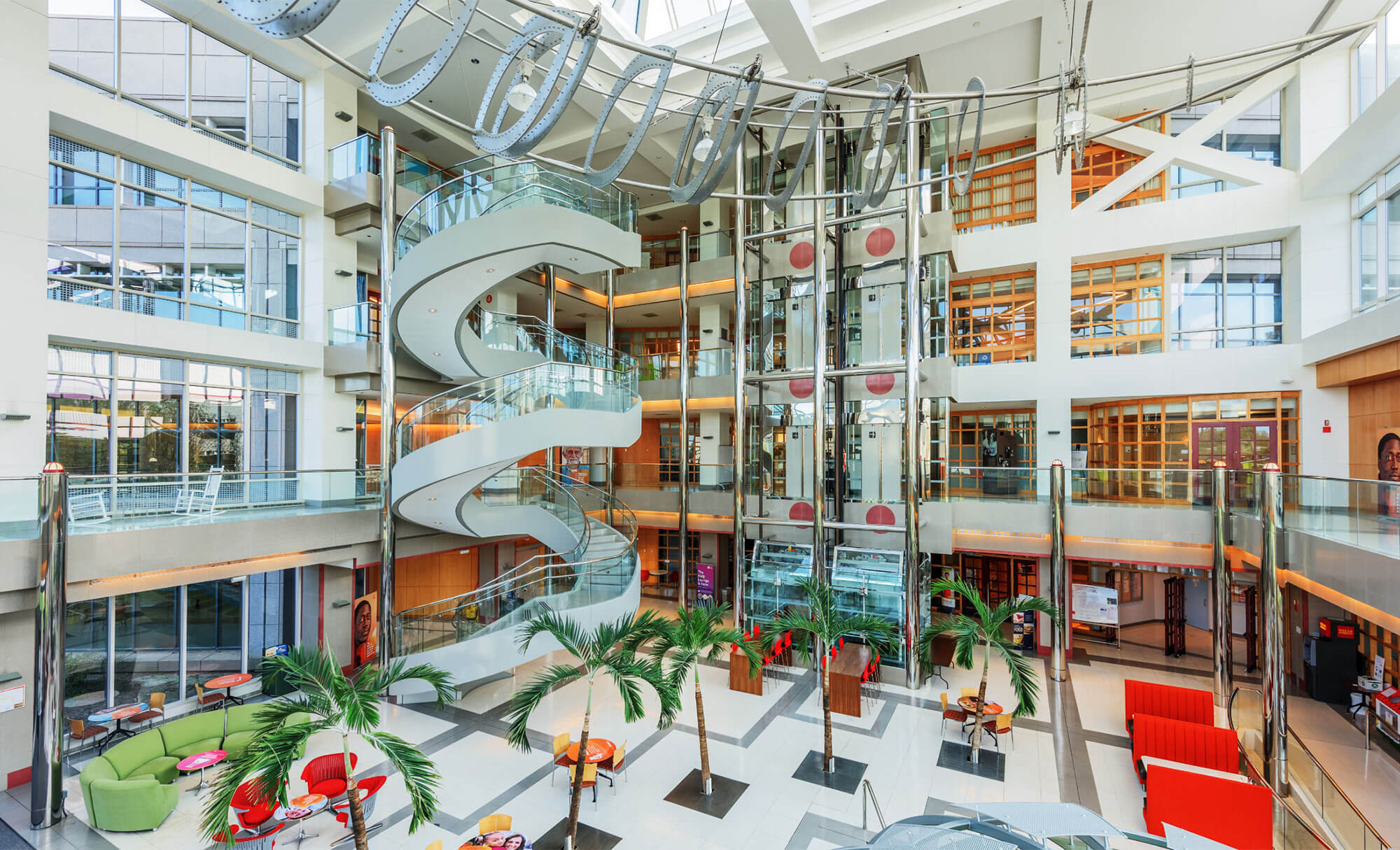Vibrant interior of Parmer RTP building with spiral staircases and tropical decor