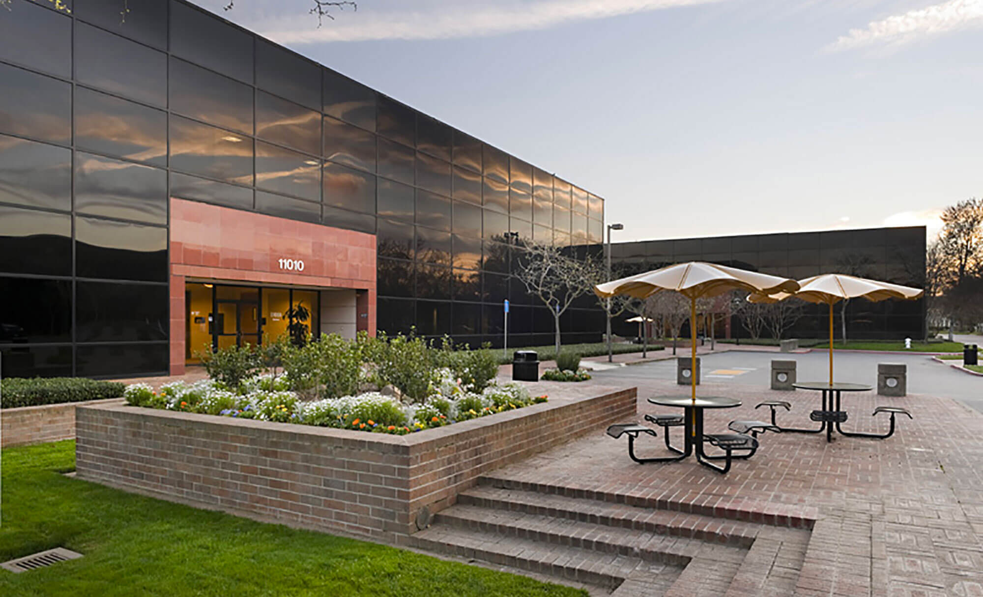 Parmer West building entrance with reflective glass and outdoor seating