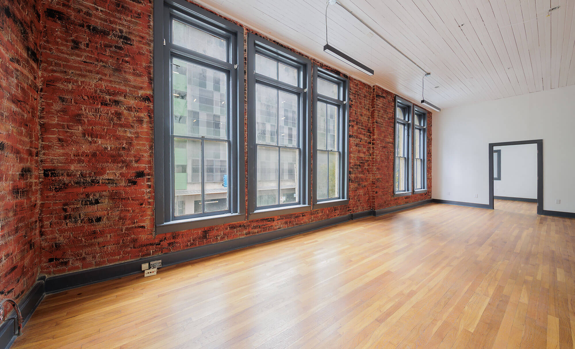 Spacious interior of Phillips Building with exposed brick walls and large windows