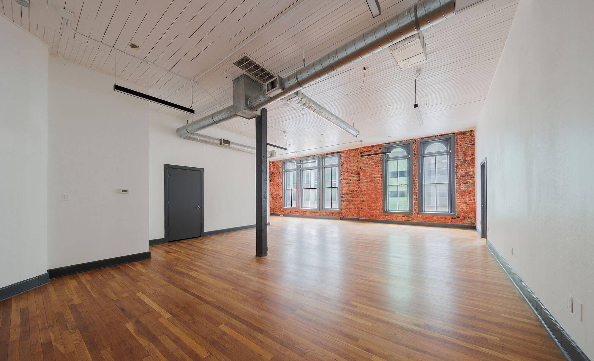 Empty office space in Phillips Building with distinctive exposed brick and modern fixtures