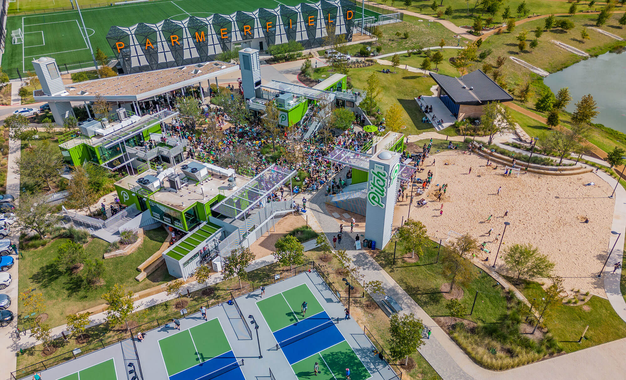 Aerial shot of The Pitch's comprehensive facility including sports courts and a large green field