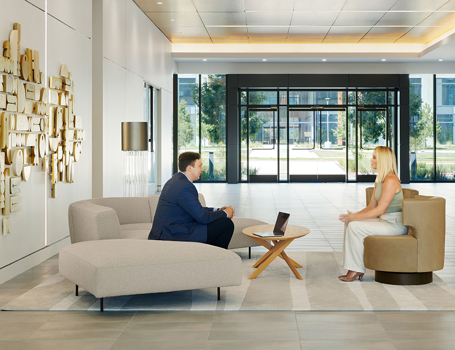 Two people sit in the lobby at Parmer 2, a development in Austin